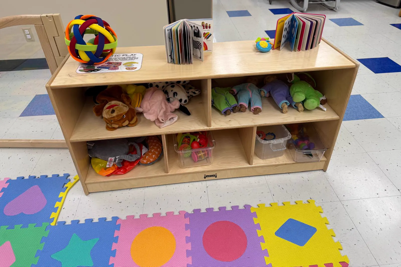 Infant room shelf with soft toys, board books and foam play mats