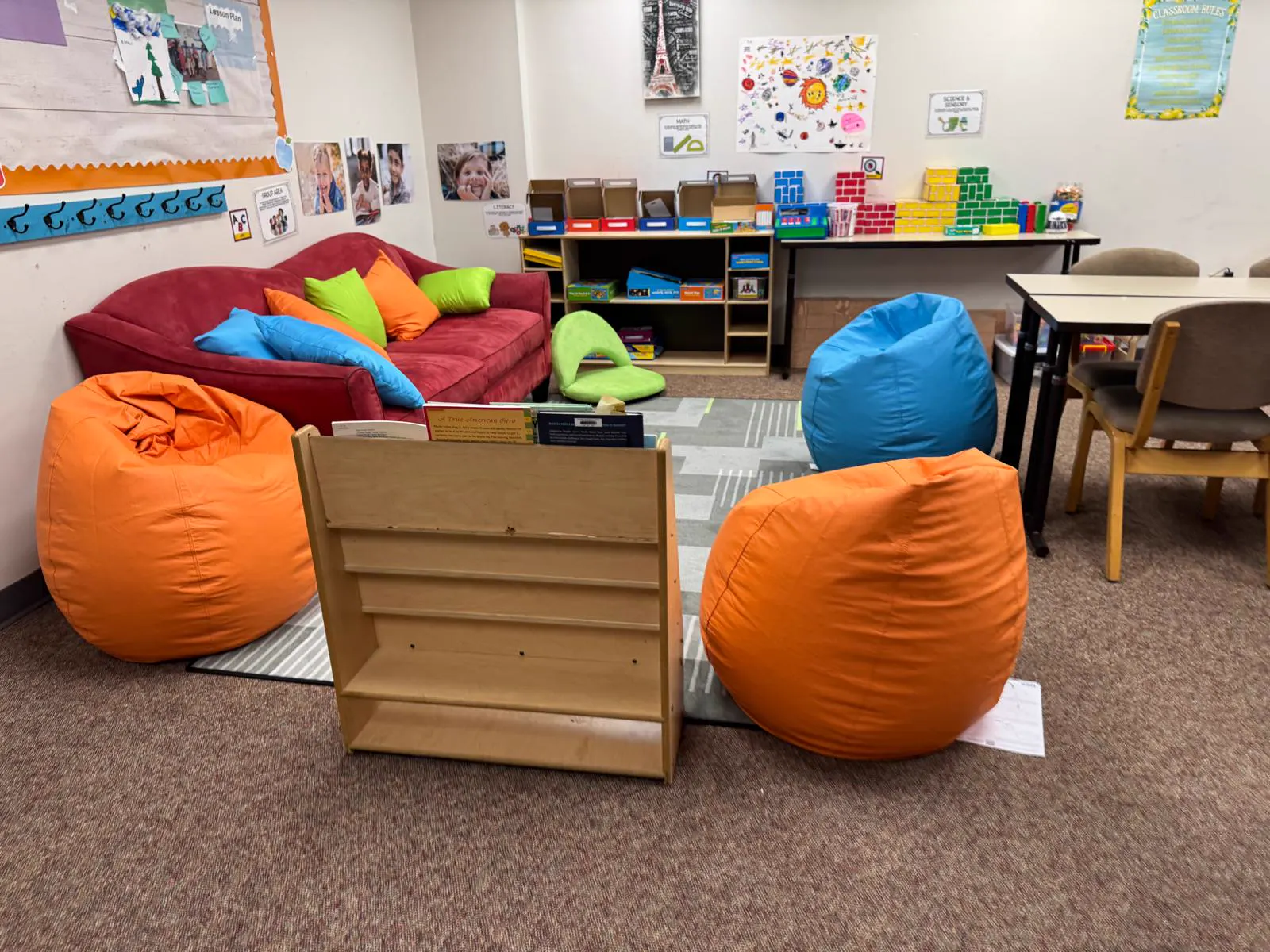 School-age lounge with bean bags, a sofa and bookshelves