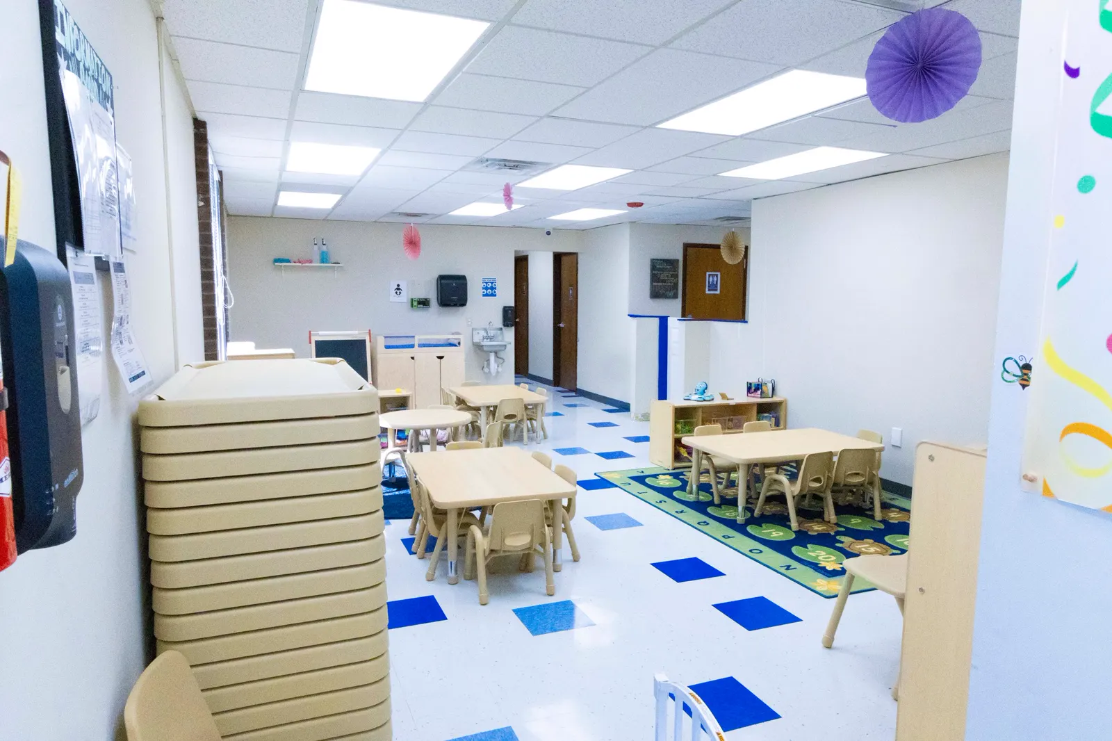 Bright, spacious classroom at Rahmah Childhood Center with child-sized tables and colorful decorations