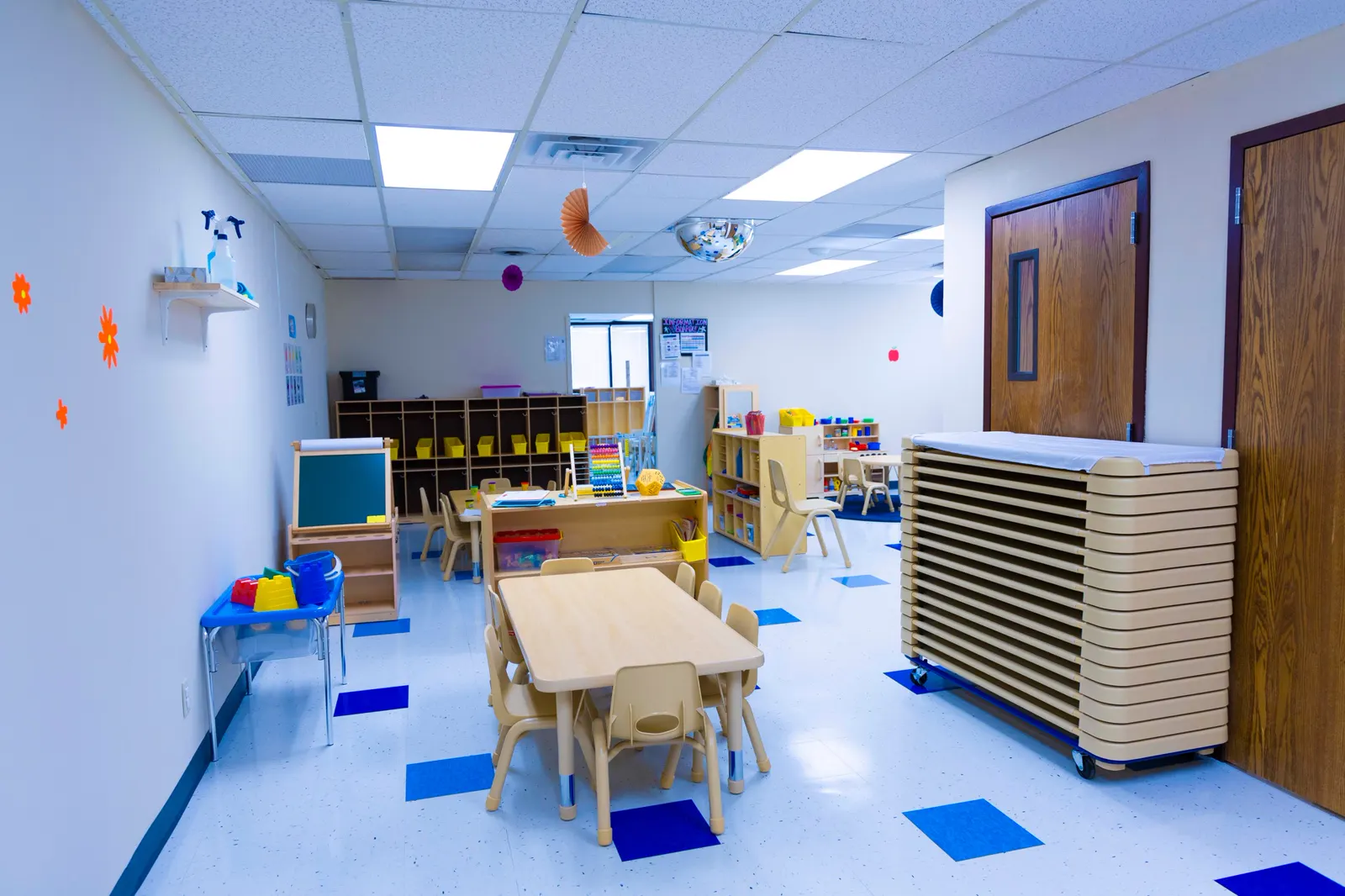 Spacious classroom at Rahmah Childhood Center with tables, shelves and learning centers