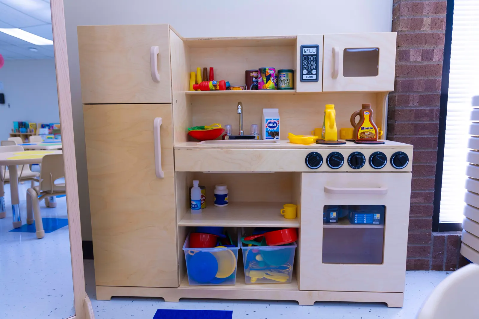Colorful child-sized play kitchen with toy food and dishes